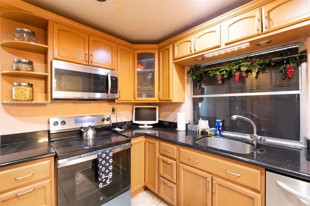 a kitchen with stainless steel appliances granite countertop a sink stove and microwave