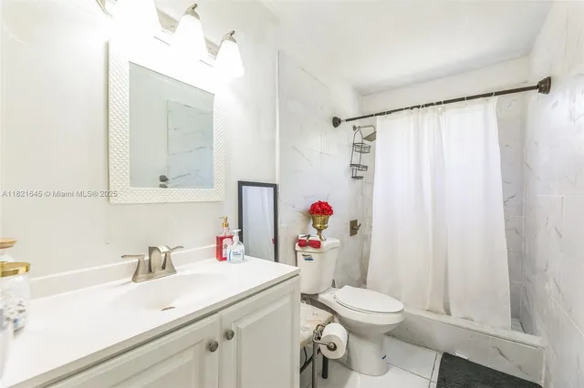 a bathroom with a sink vanity mirror and toilet