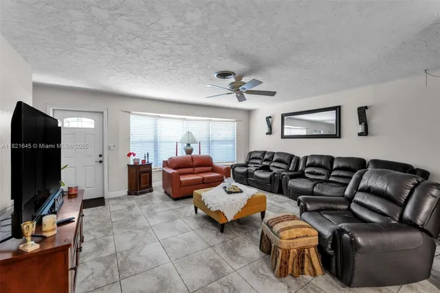 a living room with furniture a flat screen tv and a window