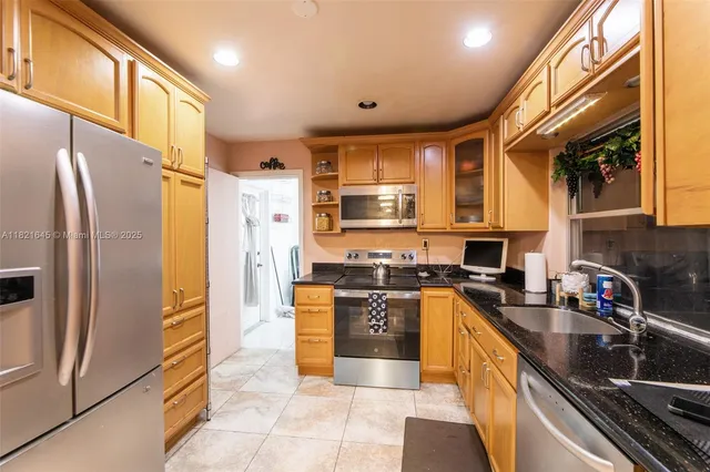 a kitchen with stainless steel appliances granite countertop a refrigerator stove and sink