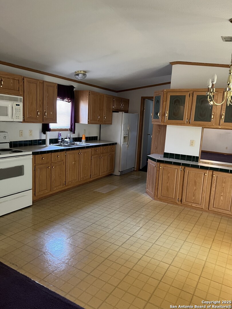 123 Chapman Street Pleasanton, TX 78064 - Photo 3 of 8 a large kitchen with cabinets and wooden floor