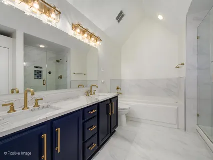 a bathroom with a sink double vanity granite tub shower and a mirror