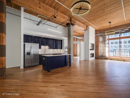 a room with stainless steel appliances kitchen island granite countertop a refrigerator and a stove