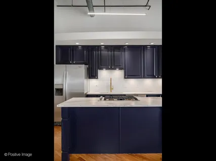 a kitchen with kitchen island a sink stainless steel appliances and cabinets