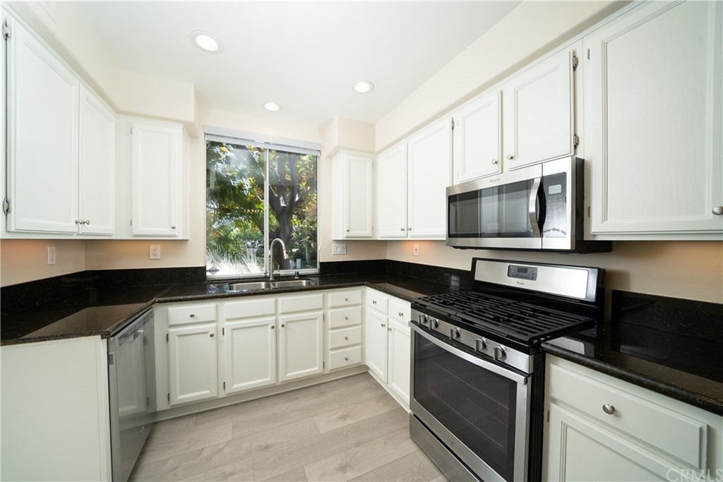 26 Le Vanto Irvine, CA 92606 - Photo 12 of 31 a kitchen with stainless steel appliances granite countertop white cabinets granite counter tops and a window