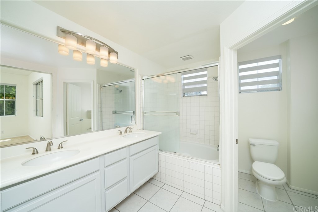26 Le Vanto Irvine, CA 92606 - Photo 23 of 31 a bathroom with a double vanity sink toilet mirror and bathtub