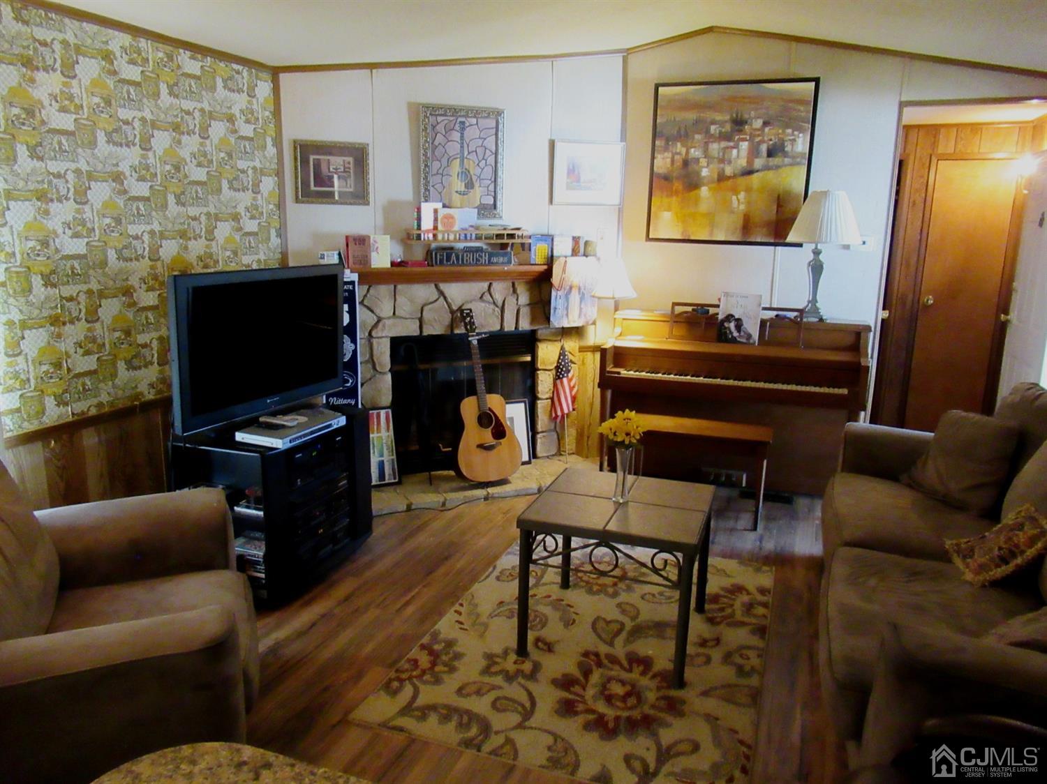 22 Emerson Road North Brunswick, NJ 08902 - Photo 4 of 14 a living room with furniture a flat screen tv and a fireplace