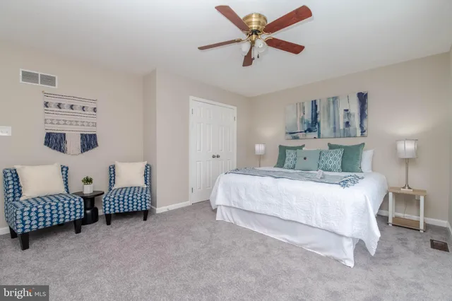 a spacious bedroom with a bed and a chandelier