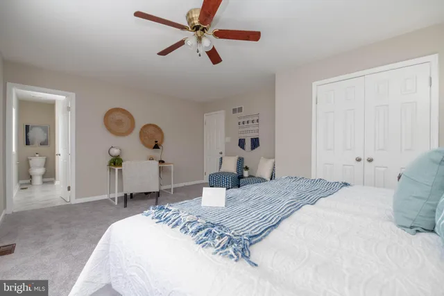 a bedroom with a bed a chandelier and dresser