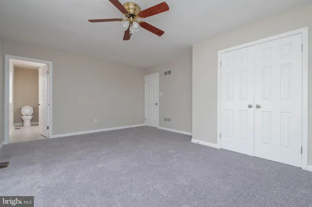 an empty room with window and a ceiling fan