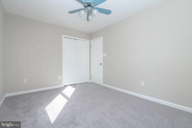 an empty room with a window and a fan