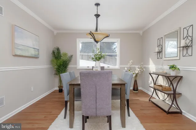 a dining room with furniture potted plants and wooden floor