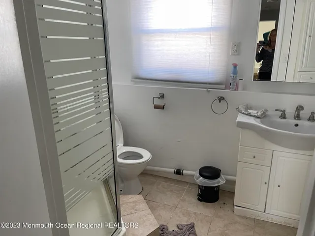 a bathroom with a sink toilet and window