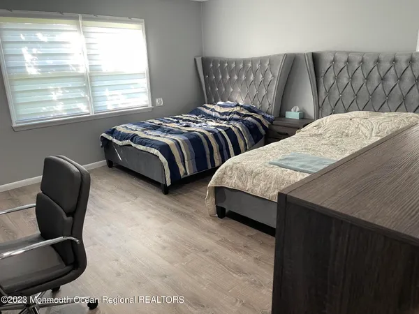 a bedroom with two beds and a chair