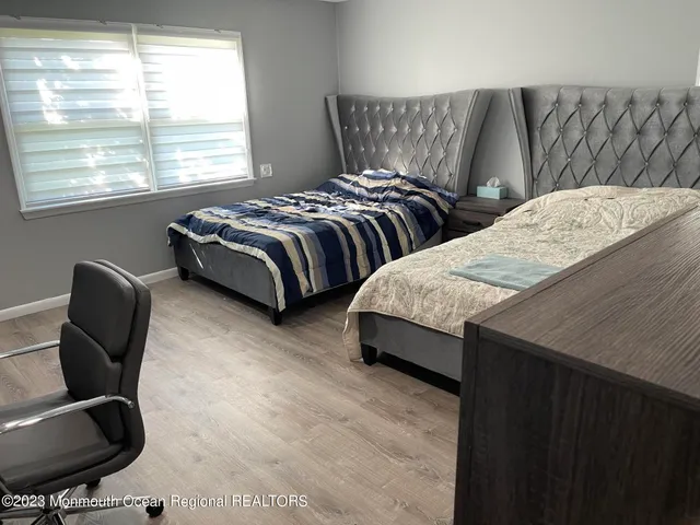 a bedroom with two beds and a chair