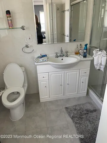 a bathroom with a granite countertop toilet sink and mirror