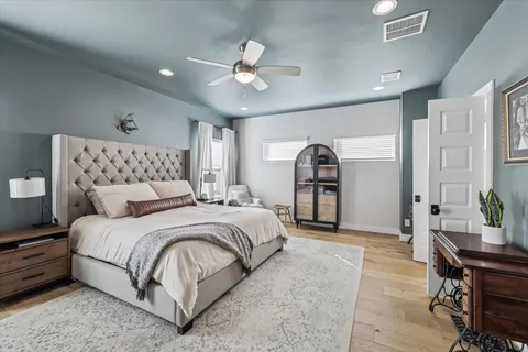 a bedroom with a large bed and a chandelier