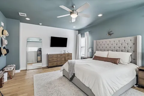 a bedroom with a large bed and a flat screen tv