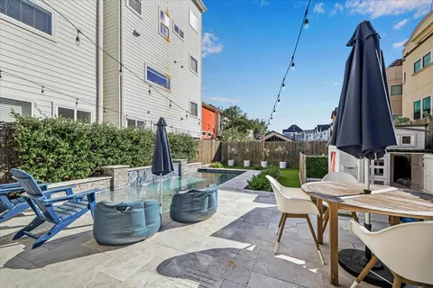 a view of a patio with table and chairs potted plants and floor to ceiling window