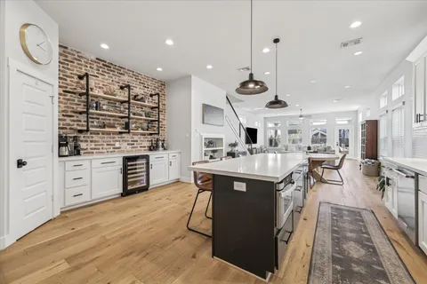 a kitchen with stainless steel appliances granite countertop a sink a stove and a wooden floors