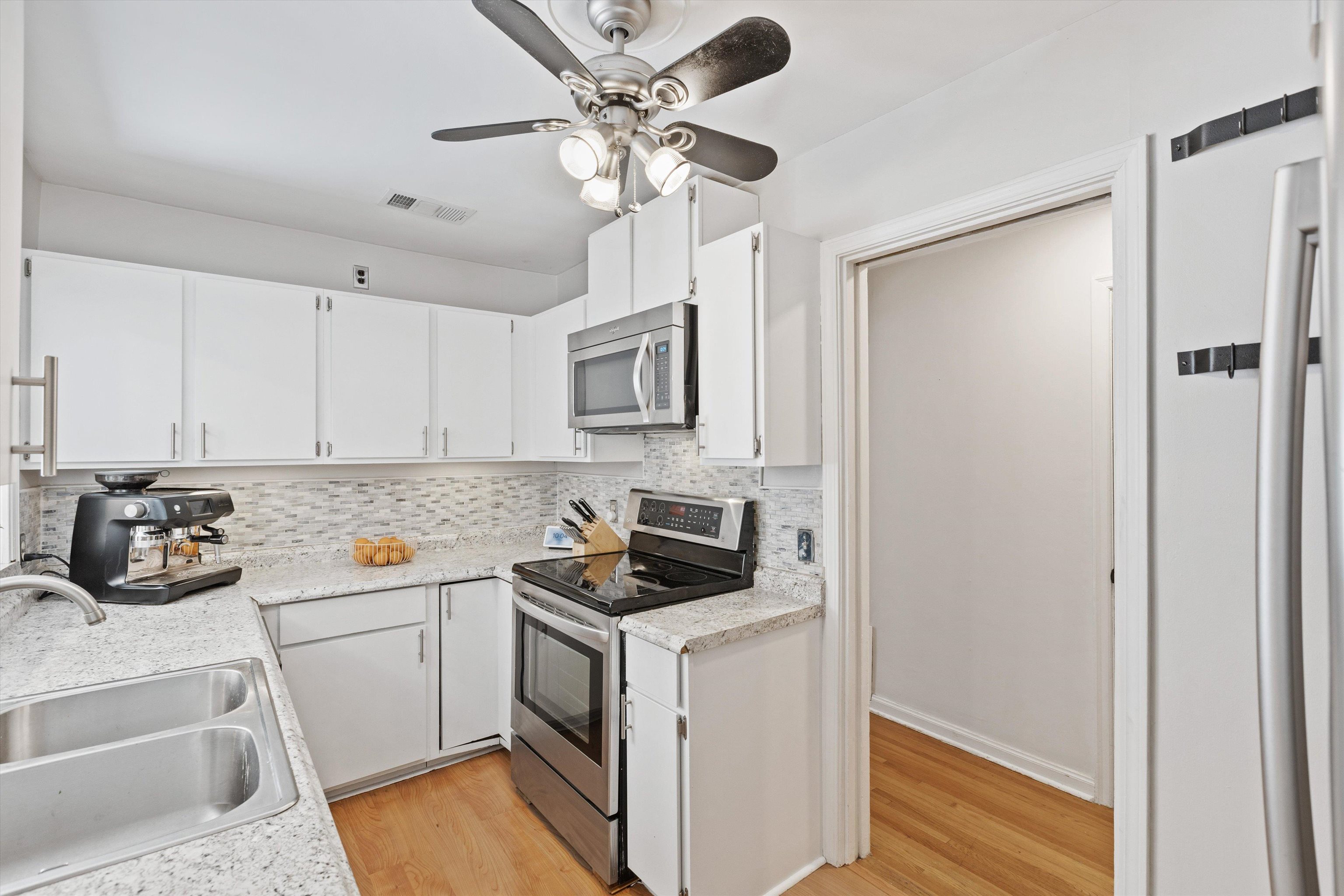 4506 Verne Road Memphis, TN 38117 - Photo 7 of 40 a kitchen with a refrigerator sink and white cabinets