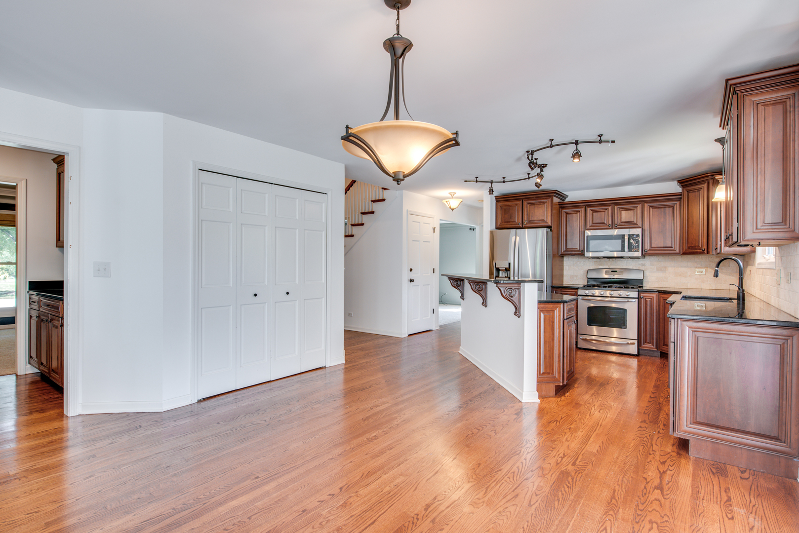 3631 Falkner Drive Naperville, IL 60564 - Photo 16 of 45 a kitchen with stainless steel appliances granite countertop a refrigerator a stove oven a sink dishwasher and a dining table with wooden floor