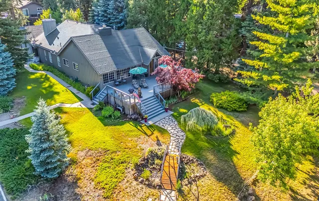 a aerial view of a house with swimming pool and large trees