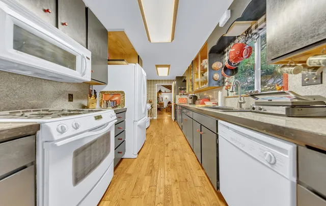 a kitchen with stainless steel appliances granite countertop lots of counter top space and wooden floor