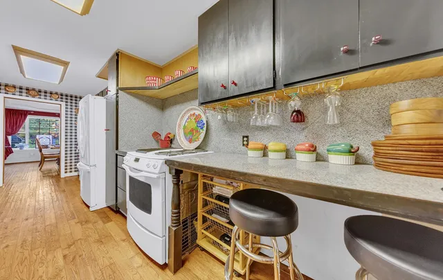 a kitchen with stainless steel appliances granite countertop a sink a stove and a wooden cabinets