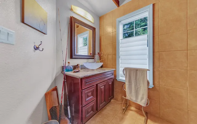 a bathroom with a granite countertop sink and a mirror