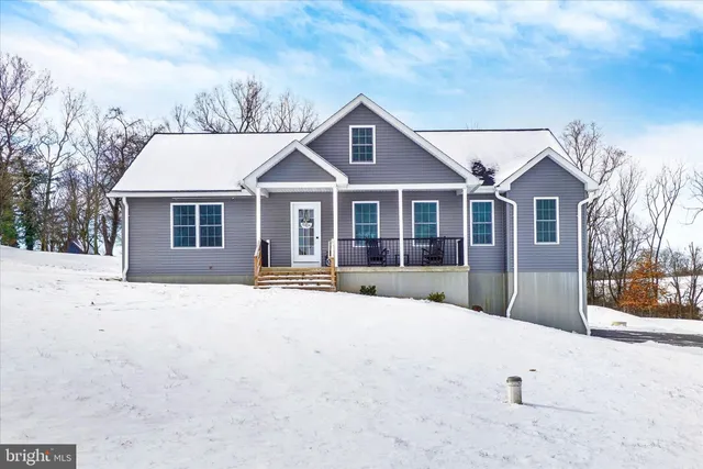 a front view of a house with a yard covered in snow