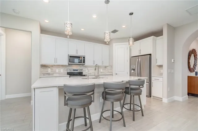 a kitchen with kitchen island white cabinets and stainless steel appliances