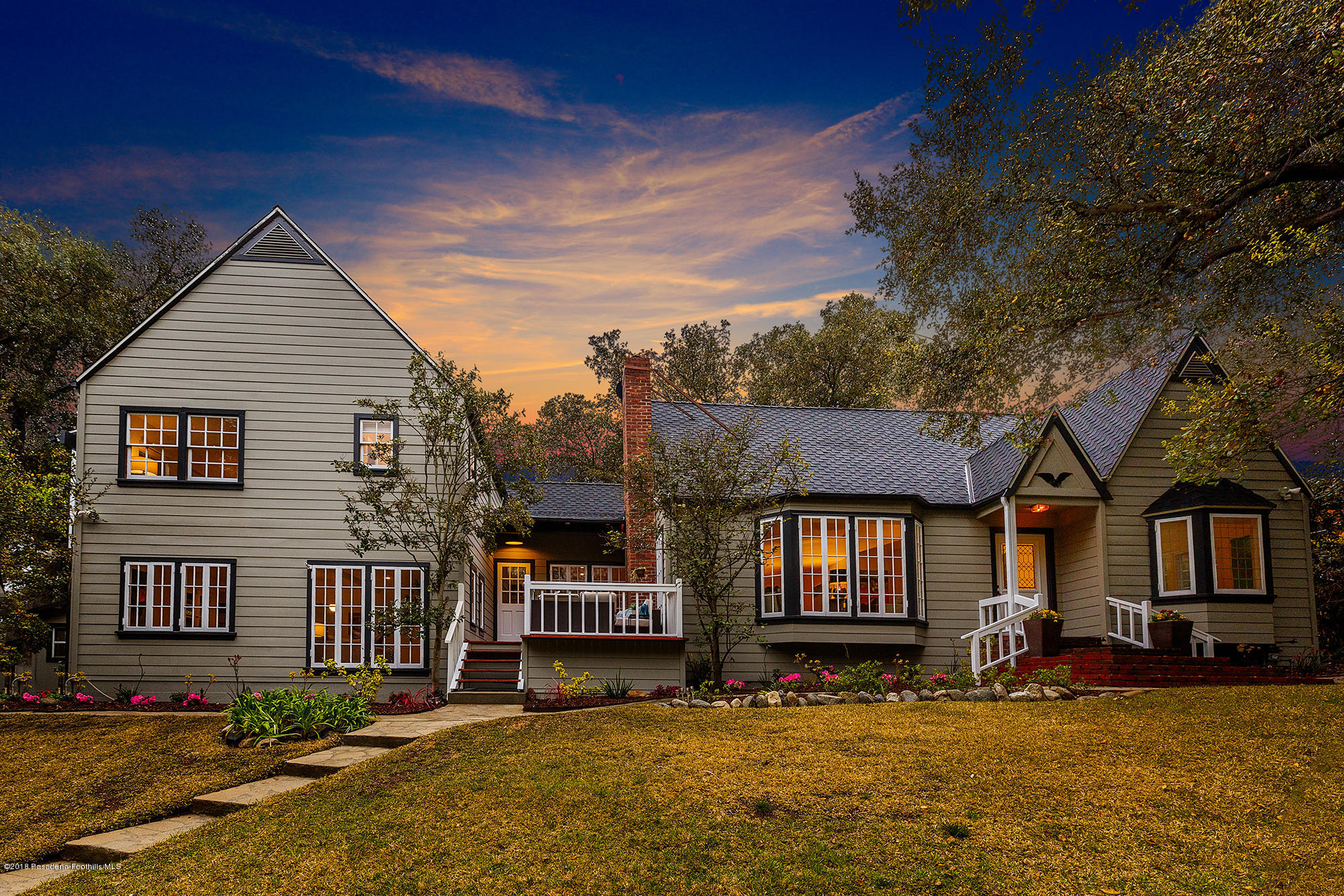 a view of a house with a large tree in a yard