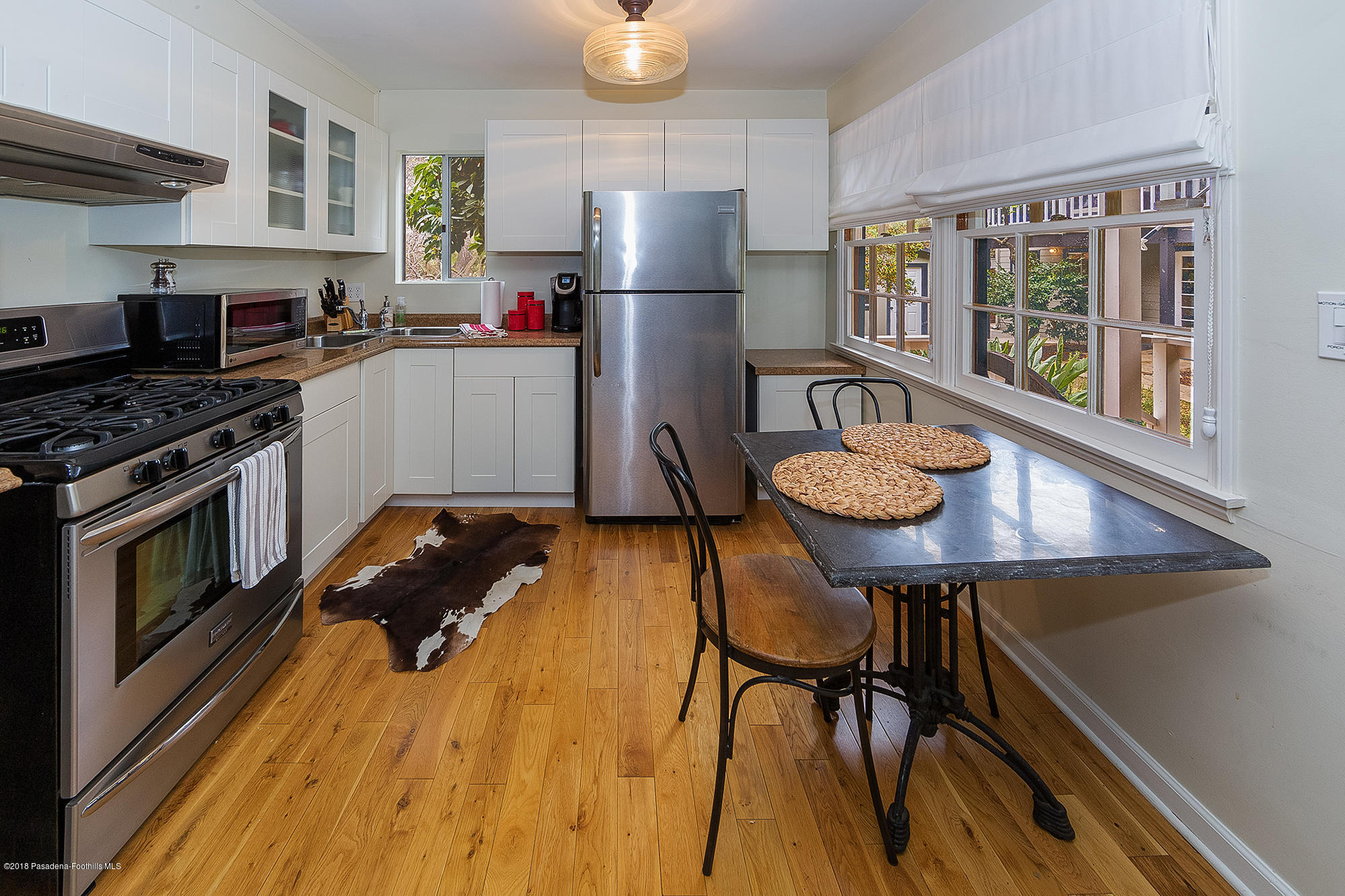 1280 Afton Street Pasadena, CA 91103 - Photo 32 of 39 a kitchen with stainless steel appliances granite countertop a stove a refrigerator and a dining table with wooden floor