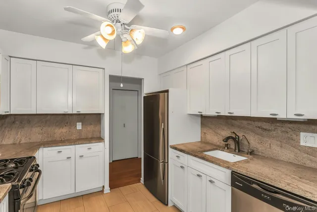a kitchen with white cabinets and stainless steel appliances