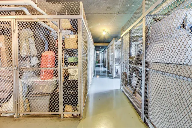 a view of a multi story residential apartment building with a yard and large trees