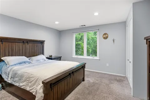 a bed sitting in a spacious bedroom next to a window