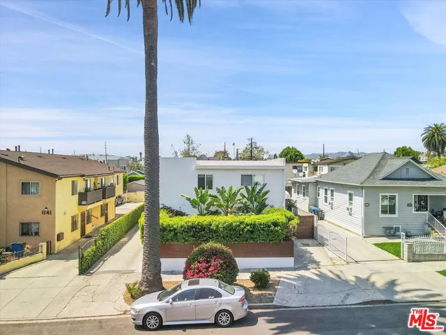 a front view of a house with a yard and potted plants