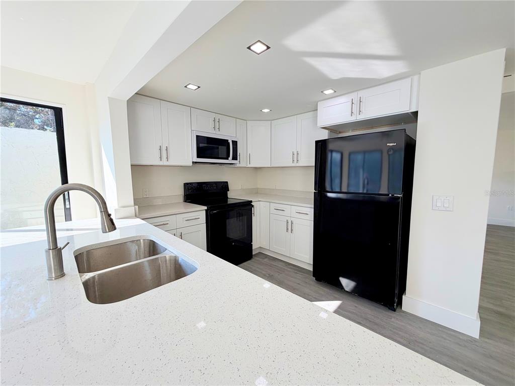 7314 Patio Row Hudson, FL 34667 - Photo 7 of 17 a kitchen with granite countertop a refrigerator and a sink