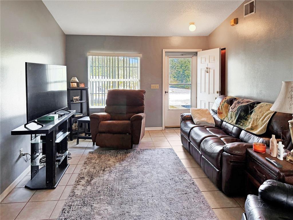 5730 Southeast 41st Street Ocala, FL 34480 - Photo 13 of 27 a living room with furniture and a flat screen tv