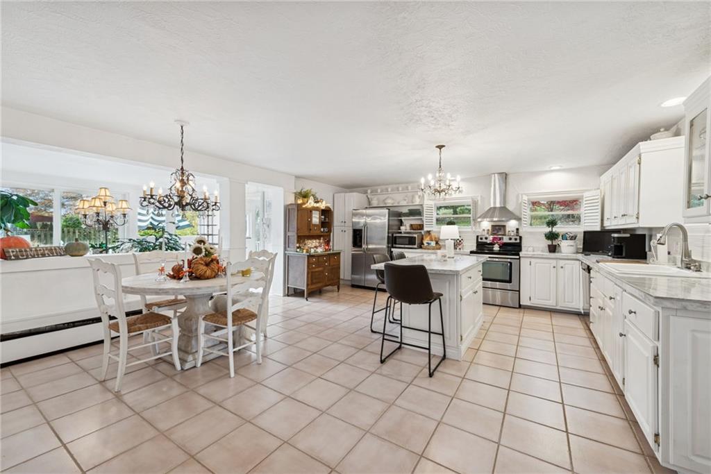 3024 Hyland Road Irwin, PA 15642 - Photo 19 of 45 a kitchen with stainless steel appliances kitchen island granite countertop a dining table chairs and a white refrigerator