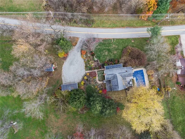 an aerial view of a house with a yard and a large tree