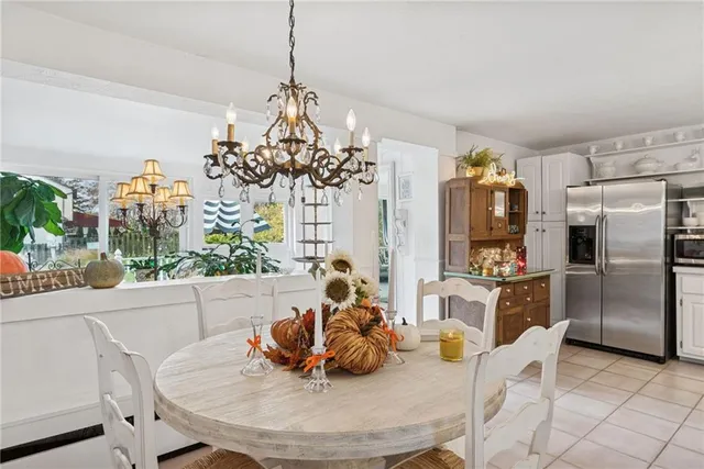 a dining room with furniture a chandelier and window