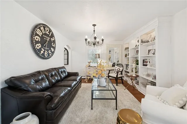a living room with furniture flowerpot and a chandelier