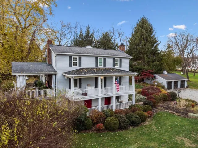 a front view of a house with a yard and trees