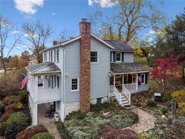 a front view of a house with yard and trees