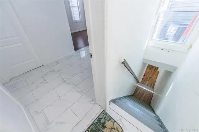a living room with stainless steel appliances furniture a window and a wooden floor