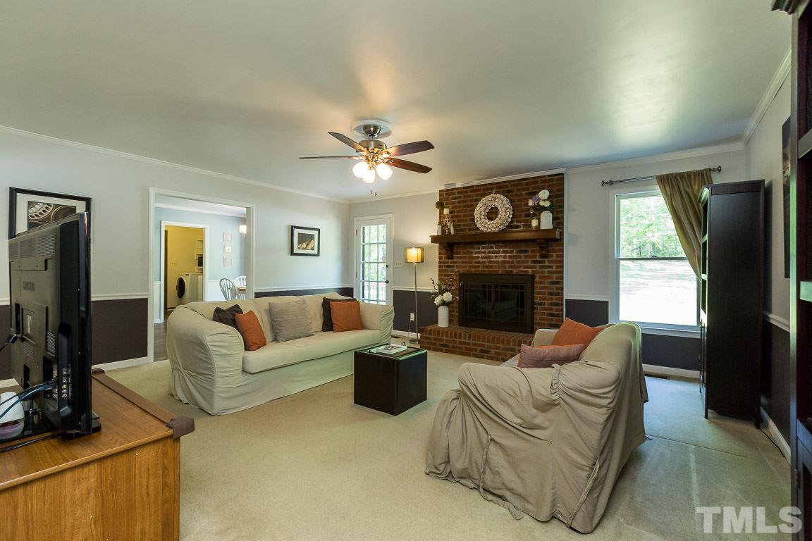 2101 Howson Road Raleigh, NC 27603 - Photo 13 of 25 a living room with furniture a fireplace and a flat screen tv