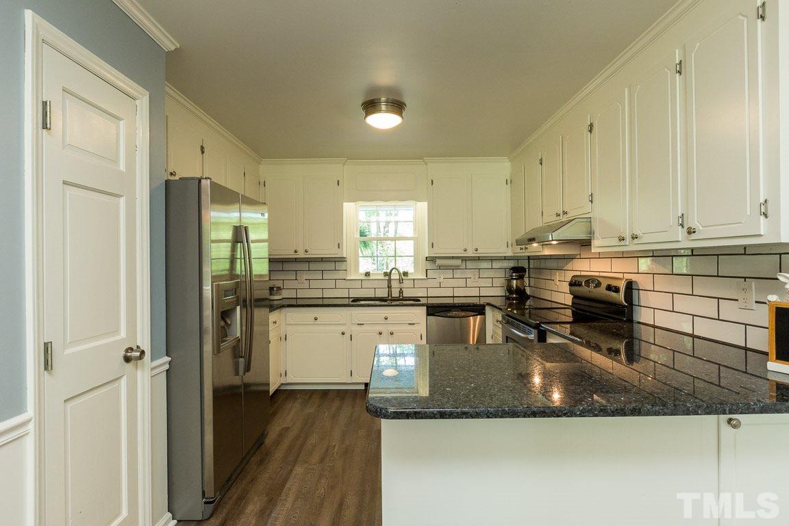 2101 Howson Road Raleigh, NC 27603 - Photo 14 of 25 a kitchen with a refrigerator a sink dishwasher stove and oven with wooden floor