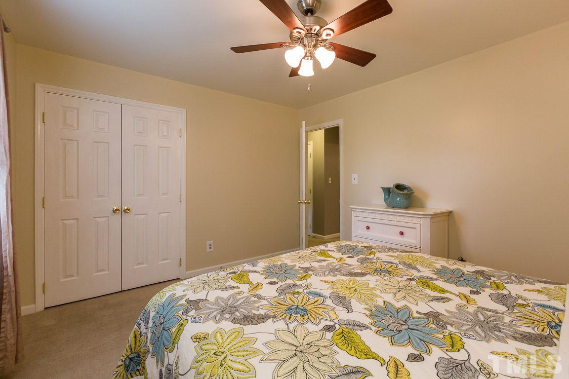 2101 Howson Road Raleigh, NC 27603 - Photo 23 of 25 a bedroom with a bed and a chandelier